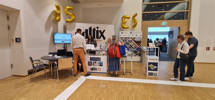 Stoisko firmy Altix w białej tonacji z balonami w kształcie liczby 35 (tyle lat istnieje firma) z odwiedzającymi je gośćmi SightCity.